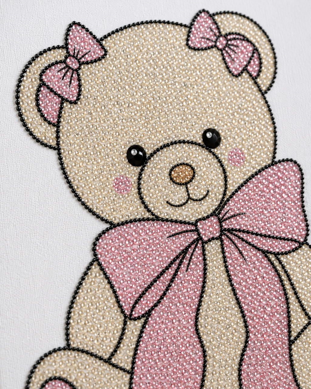 Close-up of cream and pale-pink rhinestones on the Bow Bear canvas