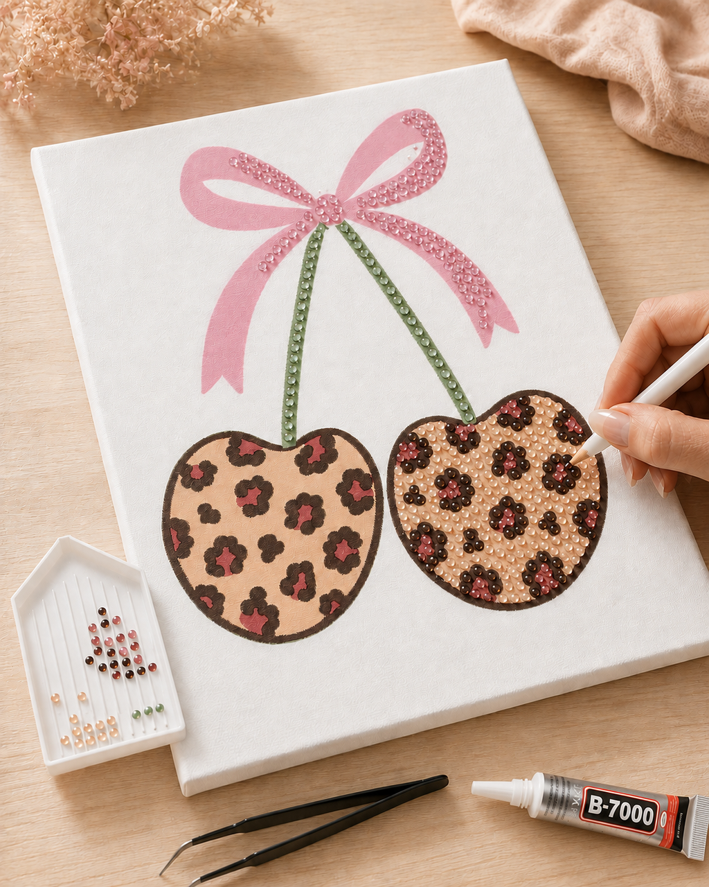 Cherry Cheetah DIY bedazzle canvas kit being decorated with colour-matched rhinestones