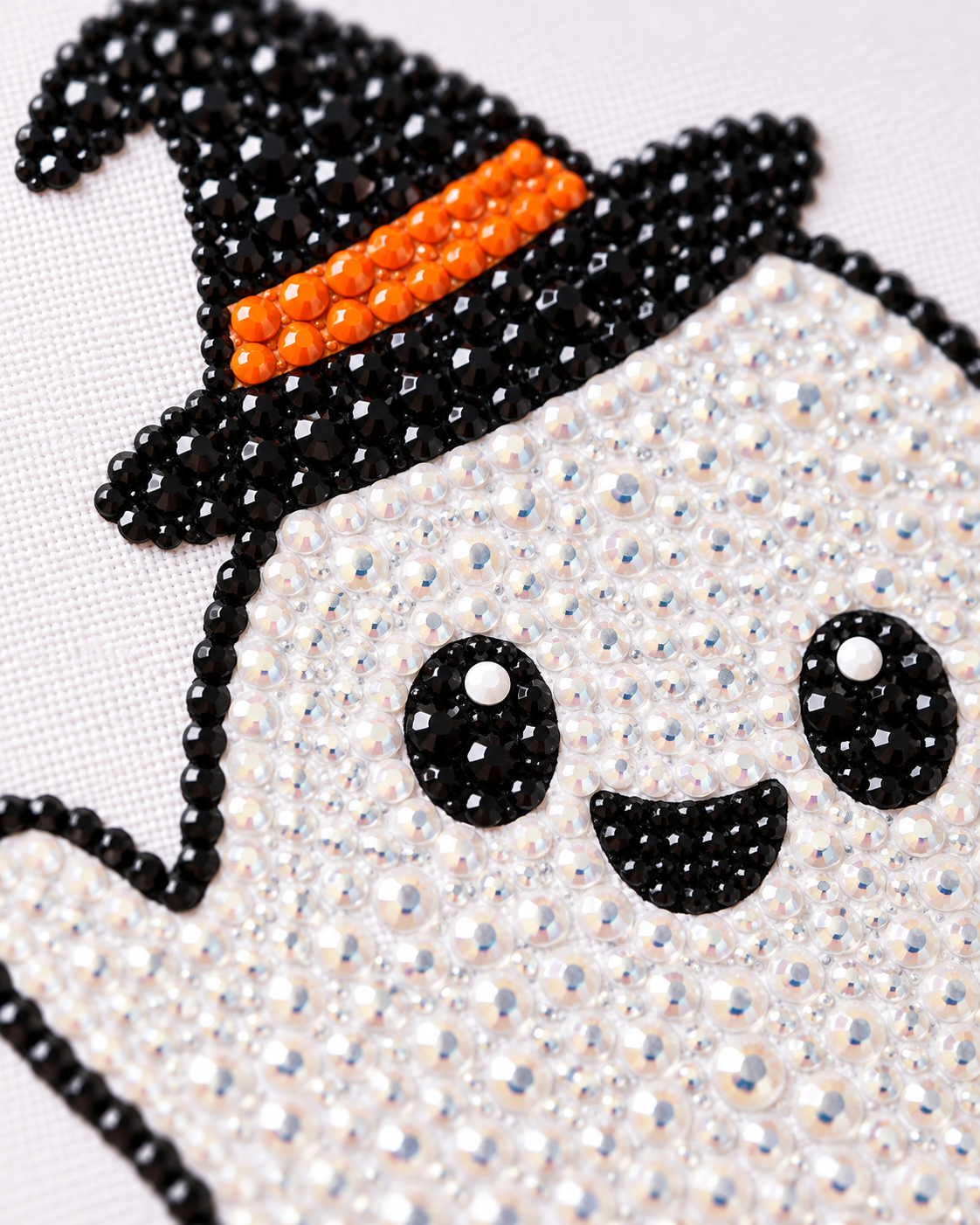 Close-up of black orange and clear rhinestones on Little Witch Ghost canvas