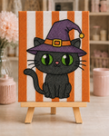 Fully bedazzled Witch Cat Halloween DIY canvas kit on a wooden easel with edge-to-edge orange and white rhinestone stripes